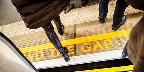 Mind the gap notice on platform on London Underground, passengers getting off train